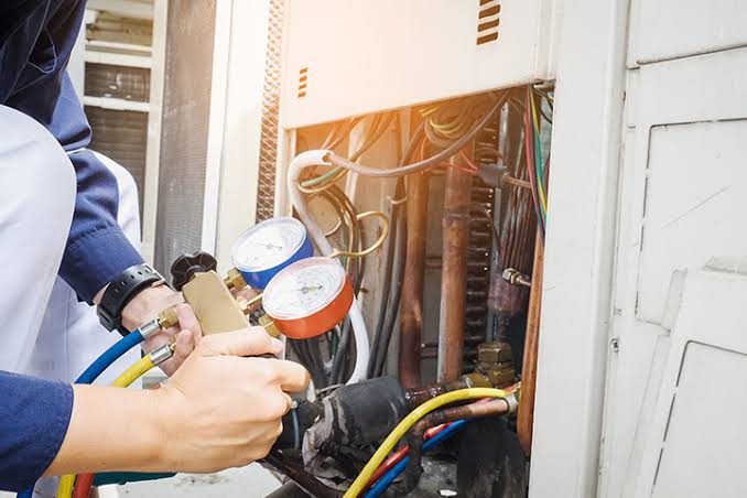 HVAC gauges connected to copper refrigerant lines on outdoor equipment