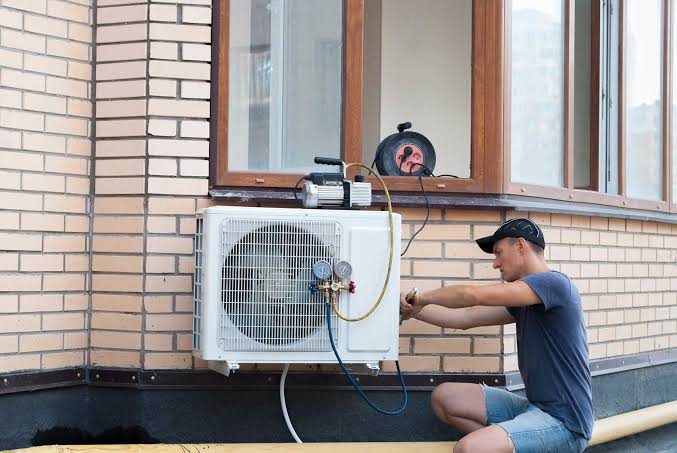 Technician installing a wall-mounted mini-split air conditioner