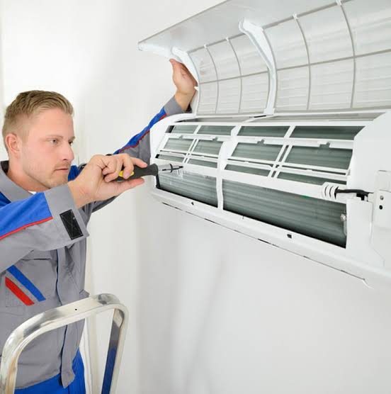 Technician servicing the interior of a wall-mounted air conditioner